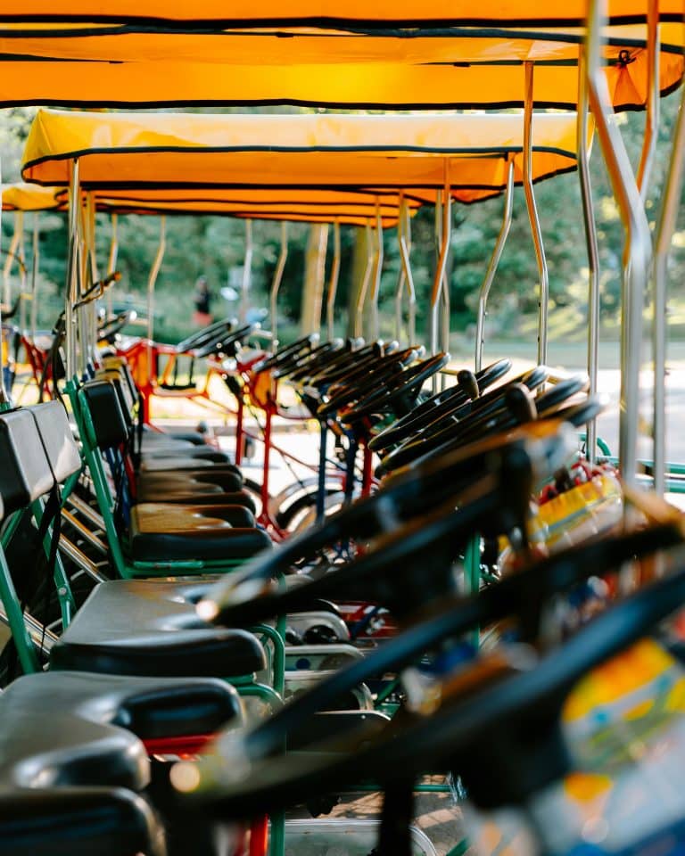 A long row of golf carts with yellow canopies parked among the trees at the swap grounds.